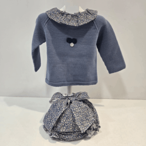 Conjunto Pangasa invierno 27 con jersey de punto azul bruma y cuello floral. Braga de tela estampada azul con lazo decorativo. Cálido, dulce y perfecto para la temporada fría.